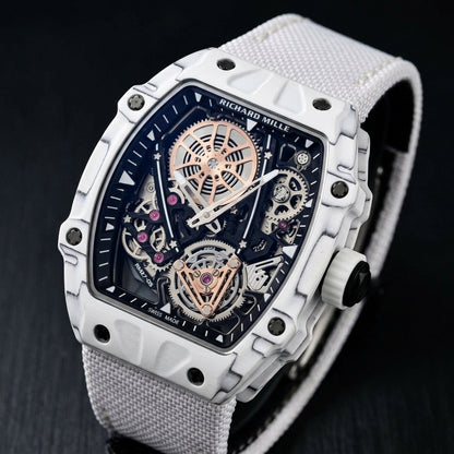 All-white carbon skeleton watch at a three-quarter angle on dark slate, grey layer lines across its curved bezel