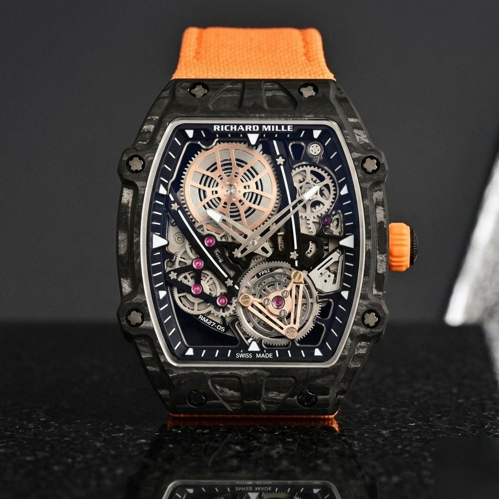 Black carbon skeleton tourbillon watch on an orange woven strap, worn on the wrist below a navy suit cuff