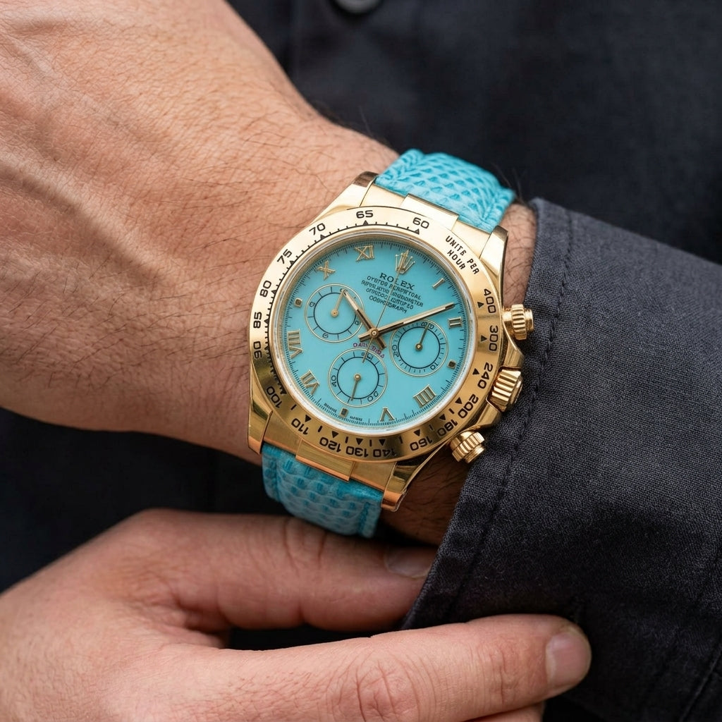 Gold-tone chronograph with a turquoise dial and a tachymeter bezel on the wrist as a shirt cuff is fastened