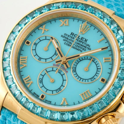 Macro of the turquoise dial with gold Roman numerals, three turquoise counters in gold rings and the aqua-blue step-cut stones at the edge