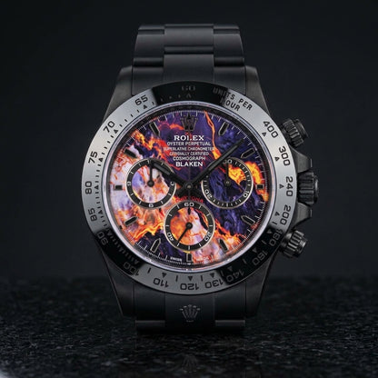 Black DLC chronograph with a violet dial veined in orange, yellow and red, standing upright on polished black granite