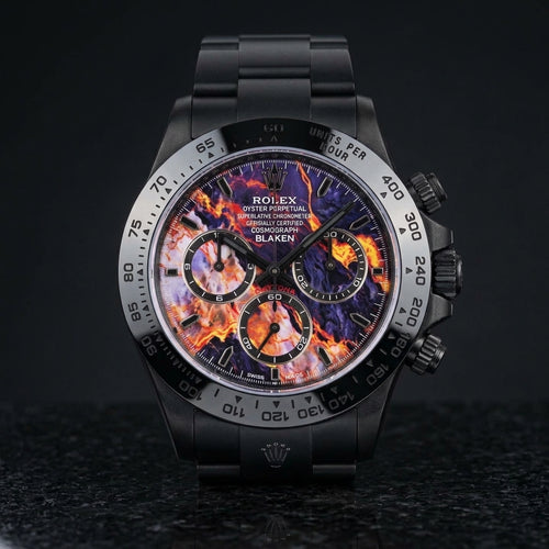 Black DLC chronograph with a violet dial veined in orange, yellow and red, standing upright on polished black granite