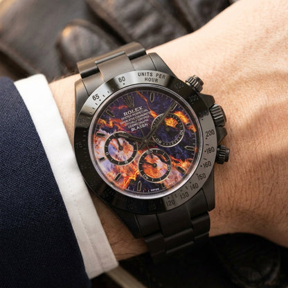 Black DLC chronograph with a violet lava dial on a black steel bracelet, worn on the wrist below a navy suit cuff