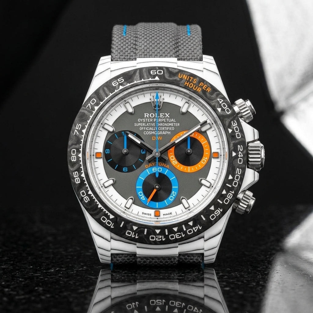 White CarboQuartz chronograph on a grey woven strap with blue stitching, worn under a cuff